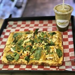 Vibrations Health, Wellness Juice Bar & Cafe - Vegan Pizza - Artisan flatbread topped with cashew cheese, tomatoes, onions, caramelized portabella mushrooms, spinach and cauliflower.