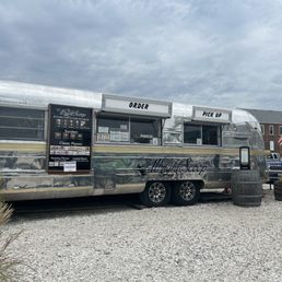a food truck parked in a gravel lot