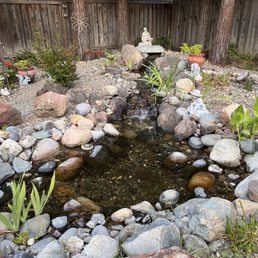 a pond surrounded by rocks a pond surrounded by rocks