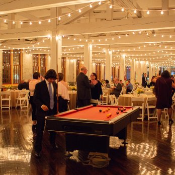 The Cracker Factory - Industrial chic wedding venue with a pool table and bistro lighting. Photo by Ciao Bella Studios. - Venues & Event Spaces Near Me - Geneva, New York
