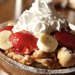 Fairgroundz - Strawberry banana funnel cake lightly dusted with powdered sugar and topped with whipped cream.