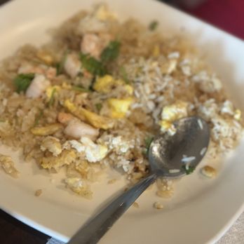 Pho Yummy - A white plate contains fried rice with scrambled egg, shrimp, and green herbs, with a metal spoon on the side. - Vietnamese Near Me - Stuart, Florida