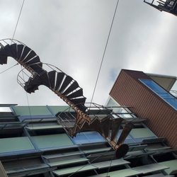 Architectural DNA - Spiral fire escape sculpture titled Architectural DNA between buildings