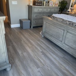 a bedroom with a bed, dresser, and mirror