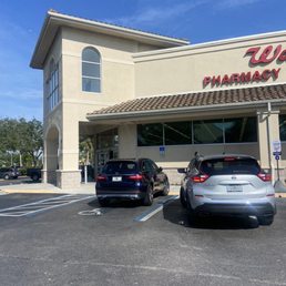two cars parked in front of a pharmacy