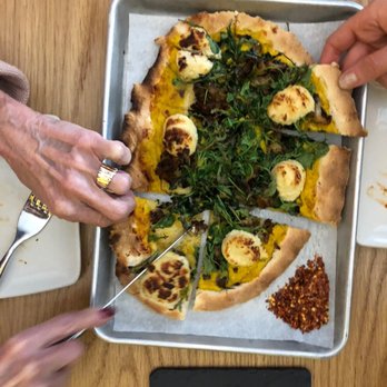 Avital -  person cutting a pizza - Food Tours Near Me