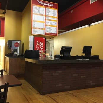 Wingin Out - a restaurant counter with a menu on the wall - Chicken Wings Near Me - Columbia, Missouri