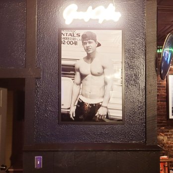 Dot Tavern - a black and white photo of a shirtless man - Dive Bars Near Me - Boston, Massachusetts