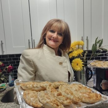 Irene Pies - a woman holding a tray of pies - Food Delivery Services Near Me Irene Pies - a woman holding a tray of pies - Food Delivery Services Near Me