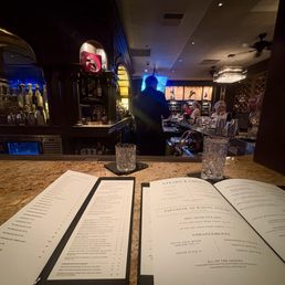 A couple of menus with a glass of water at the bar A couple of menus with a glass of water at the bar