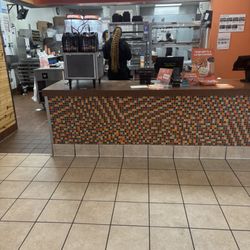 Popeye's Famous Fried Chicken - The young lady with the long hair and nails who is clearly allowed to continue practicing uncleanliness working in a restaurant