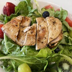 Fresh field greens and fresh fruit with grilled chicken breast