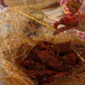 LA Crab Shack - The crawfish in my hand is spicy level 2, the ones in the bag are level 4, you can see the difference in color. - Cajun/Creole Near Me - Mesa, Arizona