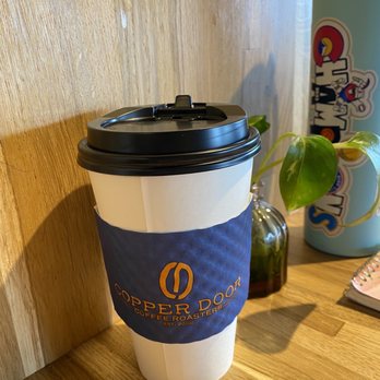 Copper Door Coffee Roasters - a cup of coffee on a table - Coffee & Tea Near Me - Littleton, Colorado Copper Door Coffee Roasters - a cup of coffee on a table - Coffee & Tea Near Me - Littleton, Colorado