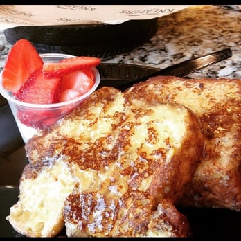 Kneaders Bakery & Cafe - Melts in your mouth French Toast! Honey Maple Syrup over two slices of French toast. Side of whip cream and strawberries. - Cafes Near Me - Gilbert, Arizona