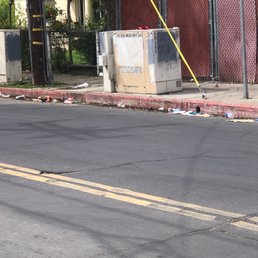 Garbage dumped in the gutter and sidewalk by 7/Eleven customers on the side of their store.