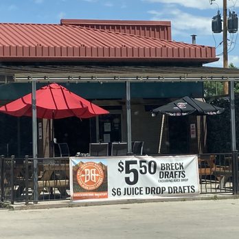 Doghouse Tavern - a doghouse with red umbrellas - Pubs Near Me - Denver, Colorado