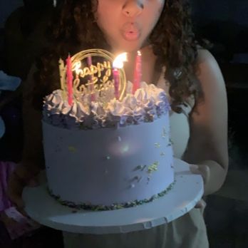 Yubana's Creations - a woman blowing out candles on a birthday cake - Custom Cakes Near Me Yubana's Creations - a woman blowing out candles on a birthday cake - Custom Cakes Near Me