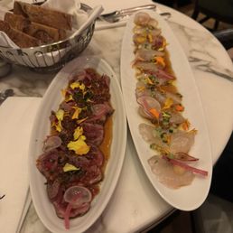 On the left is Aromatic explosion beef fillet tataki On the right is Ocean treasure sea bream sashimis On the left is Aromatic explosion beef fillet tataki On the right is Ocean treasure sea bream sashimis