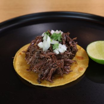 La Taqueria - Taco de Cabeza Tender and juicy beef cheek barbacoa served on a warm corn tortilla, topped with fresh onion and cilantro, with lime on the - Tacos Near Me - Dallas, Texas La Taqueria - Taco de Cabeza Tender and juicy beef cheek barbacoa served on a warm corn tortilla, topped with fresh onion and cilantro, with lime on the - Tacos Near Me - Dallas, Texas