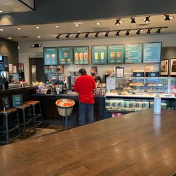 a woman standing at a counter in a coffee shop a woman standing at a counter in a coffee shop