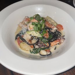 PASTA NEGRA - 8/10 Squid ink pasta, spinach, fennel, brussels sprouts, scallops, shrimp, calamari, roasted garlic salsa, asiago cheese. PASTA NEGRA - 8/10 Squid ink pasta, spinach, fennel, brussels sprouts, scallops, shrimp, calamari, roasted garlic salsa, asiago cheese.