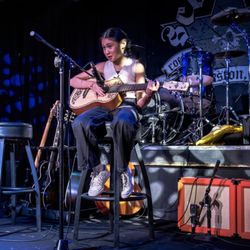Avery playing classical guitar for a live audience.