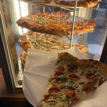Main Street Pizza - a hand holding a slice of pizza - Pizza Near Me - Chico, California