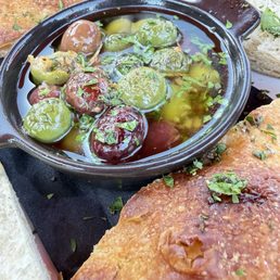Warm olive appetizer with herbs, garlic and olive oil. Served with toasted bread.