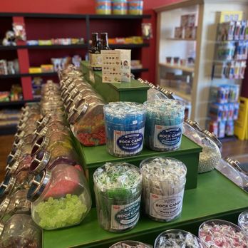 Back In Time Popcorn - a display of candy - A candy shop shelf features jars of colorful candies and rock candy sticks, with shelves of other sweets in the background. - Candy Stores Near Me - Conroe, Texas