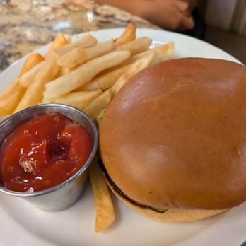 District Tap - Kids Cheeseburger and Fries - A cheeseburger with a shiny bun, French fries, and a cup of ketchup on a white plate at a restaurant. - Sports Bars Near Me - Washington, DC, District of Columbia