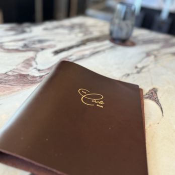 Emilia's - a close up of a menu book on a table - Mediterranean Near Me - Fort Worth, Texas