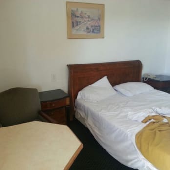 Motel Budget Inn - Unmade bed, table in foreground - Hotels Near Me - Greenfield, California Motel Budget Inn - Unmade bed, table in foreground - Hotels Near Me - Greenfield, California
