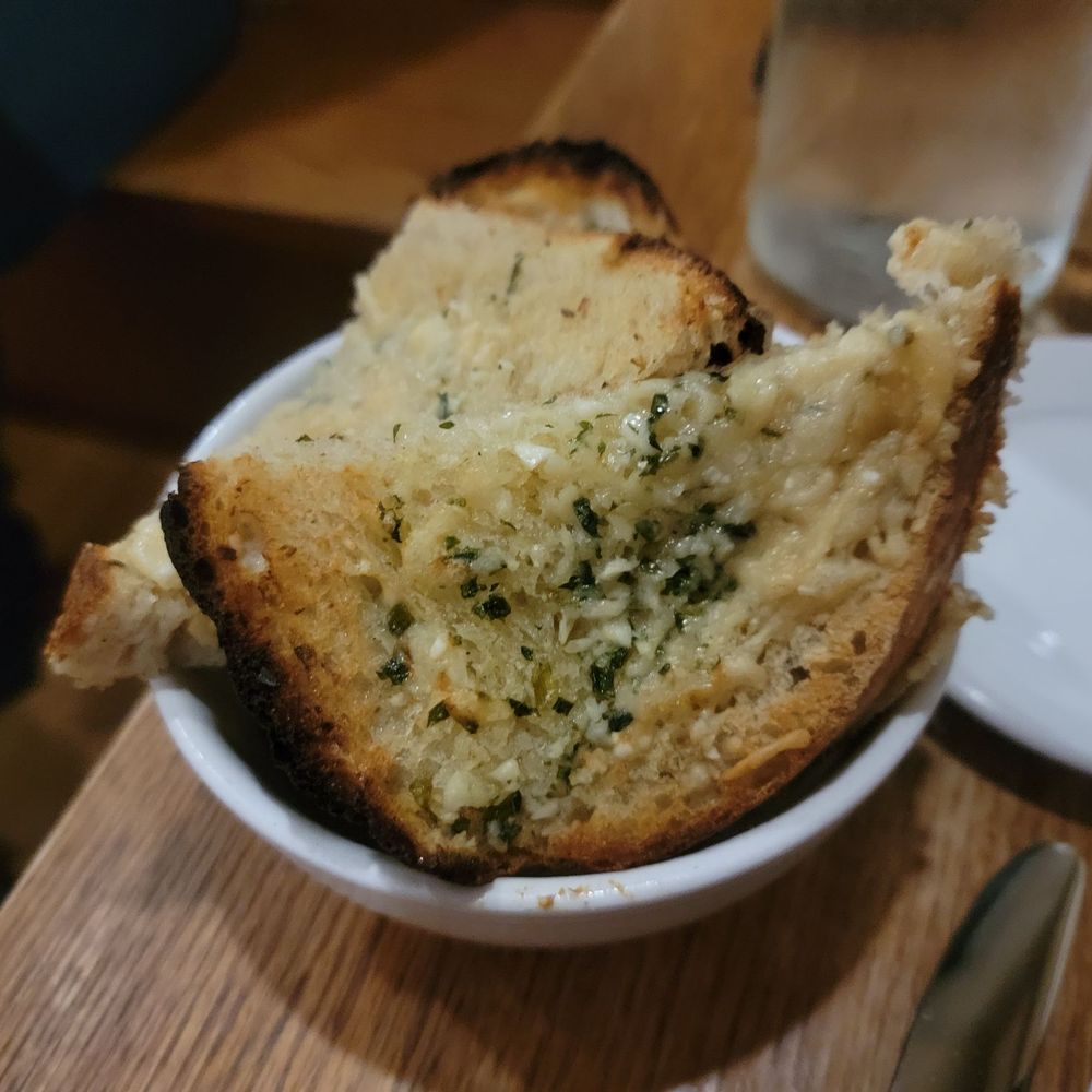 The Corner Room - a piece of garlic bread in a bowl - Italian Near Me - Portland, Maine