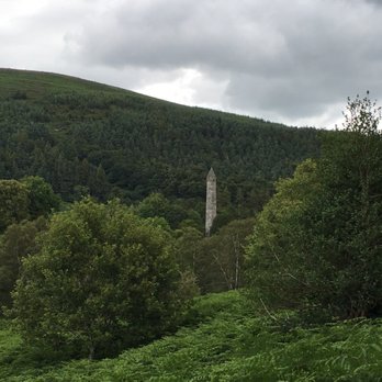 Wild Rover Tours - The round tower of Glendalough from near one of the lakes - Tours Near Me - Dublin, D Wild Rover Tours - The round tower of Glendalough from near one of the lakes - Tours Near Me - Dublin, D
