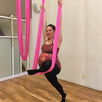 The Flying Doula - Michelle practicing flying pigeon, a shape that stretches the front of the back leg, and the piriformis, helping with sciatica. - Doulas Near Me The Flying Doula - Michelle practicing flying pigeon, a shape that stretches the front of the back leg, and the piriformis, helping with sciatica. - Doulas Near Me