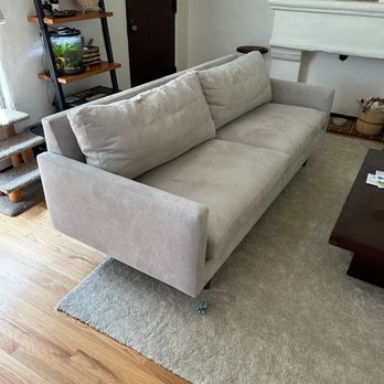 Kaiyo - A beige fabric sofa with cushions is placed on a gray rug in a living room with wooden flooring and nearby furniture and decor. - Furniture Stores Near Me - Chino, California