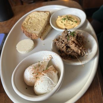 Coronet Cafe - A serving plate holds slices of bread, mayonnaise, shredded meat, and two soft-boiled eggs garnished with paprika, served with a small dish of mustard. - Cafes Near Me - Tucson, Arizona