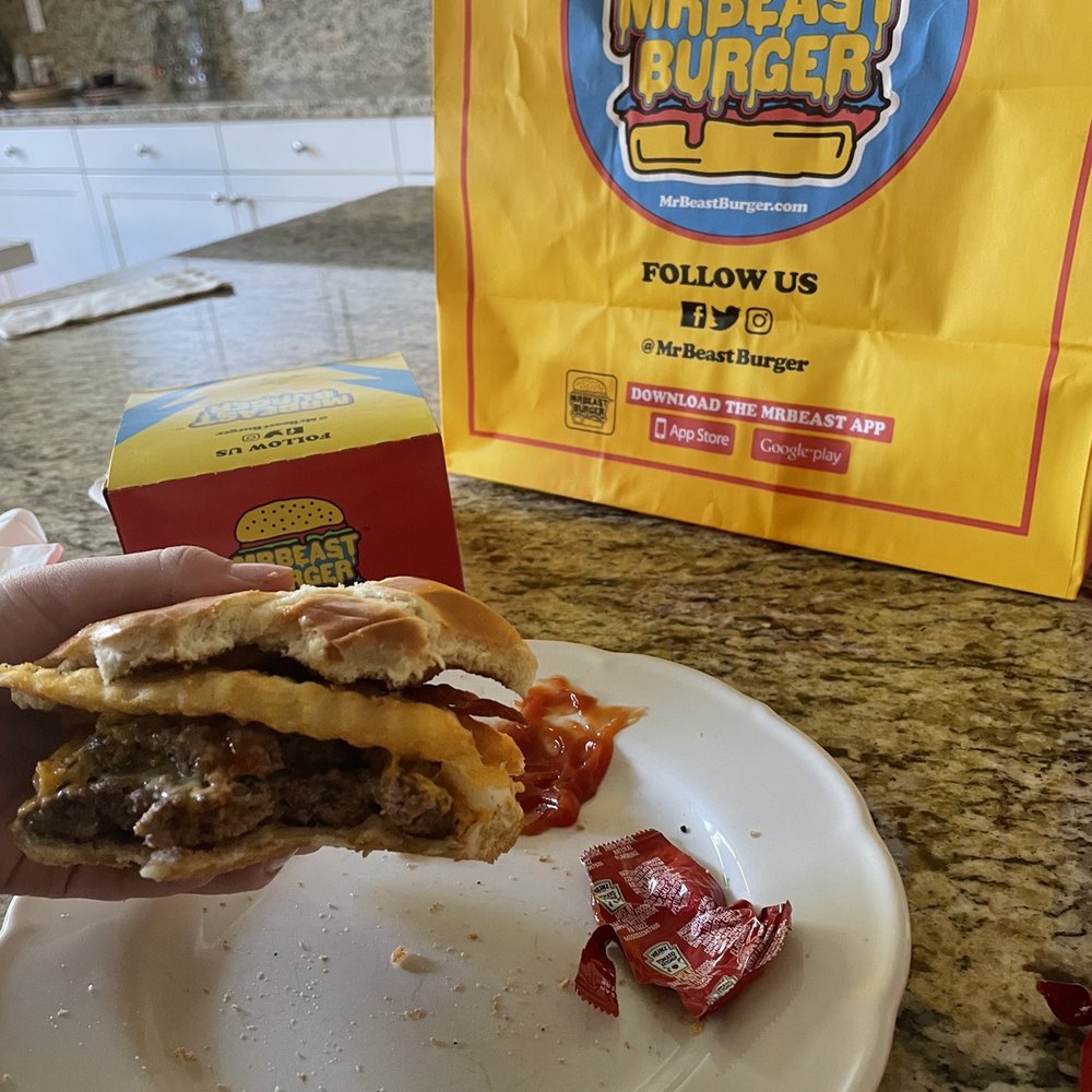 MrBeast Burger - a hand holding a half eaten sandwich - Food Delivery Services Near Me - Foothill Ranch, California MrBeast Burger - a hand holding a half eaten sandwich - Food Delivery Services Near Me - Foothill Ranch, California