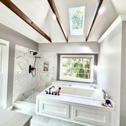 Charlie Angell - The House Doctor - Custom tub surround, jetted/heated tub, wooden beams, tile floor and shower, schluter waterproofing, and matching stone tops.