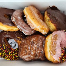 Assorted donuts: chocolate frosted yeast, glazed cake, glazed yeast, boston cream, holiday chocolate frosted, strawberry chocolate frosted.