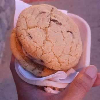 3 Scoops - a hand holding a cookie sandwich - Ice Cream & Frozen Yogurt Near Me - Bradford, Ontario 3 Scoops - a hand holding a cookie sandwich - Ice Cream & Frozen Yogurt Near Me - Bradford, Ontario