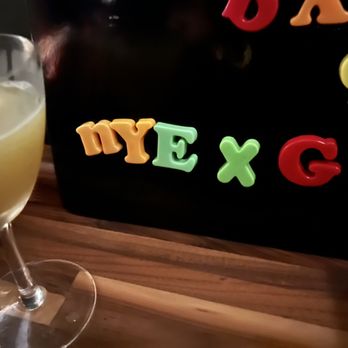 Goodnight Kenny - a glass of orange juice next to a chalk board - Bars Near Me - Poughkeepsie, New York