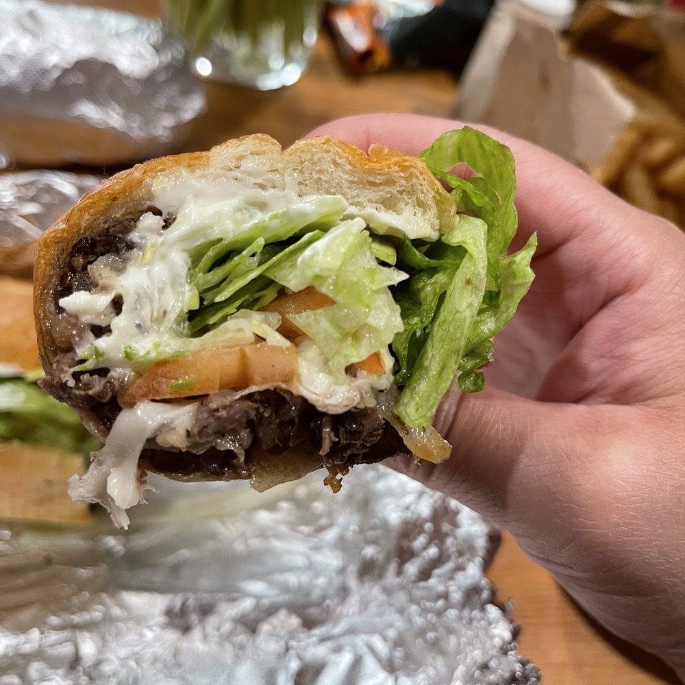 The Broiler - a hand holding a hamburger - Pizza Near Me - Arlington, Virginia The Broiler - a hand holding a hamburger - Pizza Near Me - Arlington, Virginia