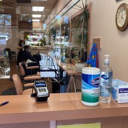 Close up of the counter with plastic cover showing disinfectant wipes, hand sanitizer and extra face masks.