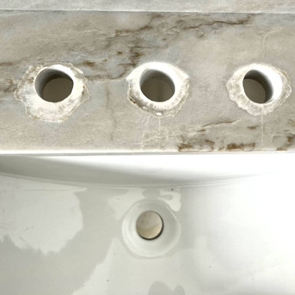 Bruising on master vanity faucet holes. We had to find a drop in sink to cover them. Bruising on master vanity faucet holes. We had to find a drop in sink to cover them.