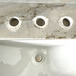 Bruising on master vanity faucet holes. We had to find a drop in sink to cover them. Bruising on master vanity faucet holes. We had to find a drop in sink to cover them.