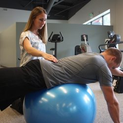 Quest Physical Therapy - Ball stability exercise with a patient who has low back pain