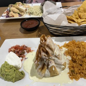 Fiesta Azul Tequila House - Chimichanga surrounded by tasty goodness. Mahi mahi tacos and chips in background. - Mexican Near Me - Melbourne, Florida