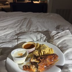 Another Wing By DJ Khaled - Wings and fries in bed.